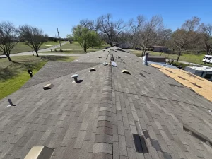 Shingle roof undergoing repair with missing and chalk-marked shingles in McKinney, Texas